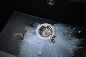 Clogged kitchen sink with slow-draining water