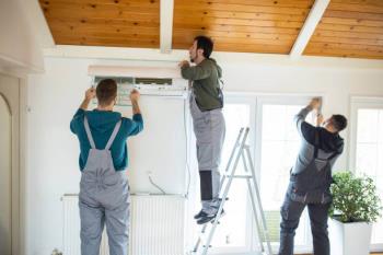ALT Text: HVAC technician installing a new mini-split system indoor unit