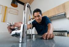 Image showing a homeowner checking low water pressure in the faucet